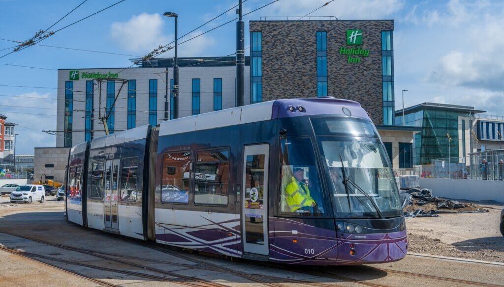 A photo showing a tram at the Talbot Gateway. In the background is a hotel and office building